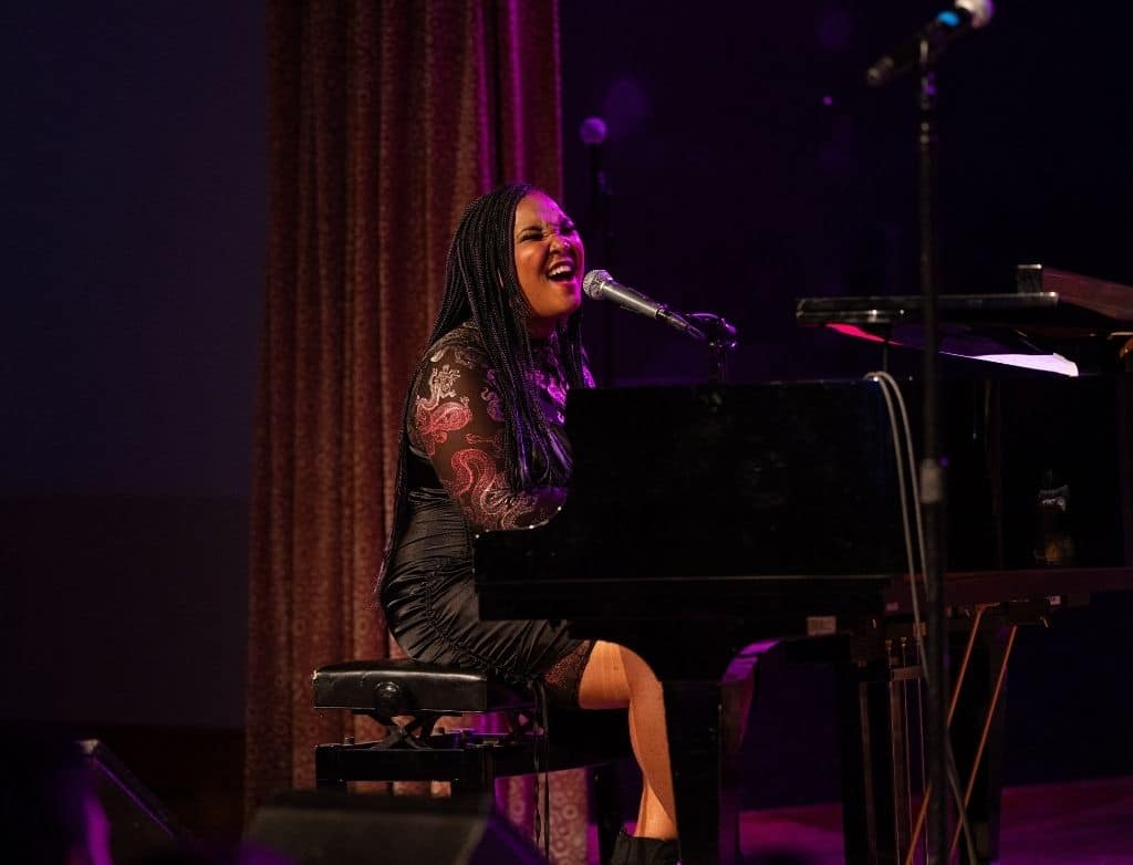 Alexis Lombre playing piano and singing