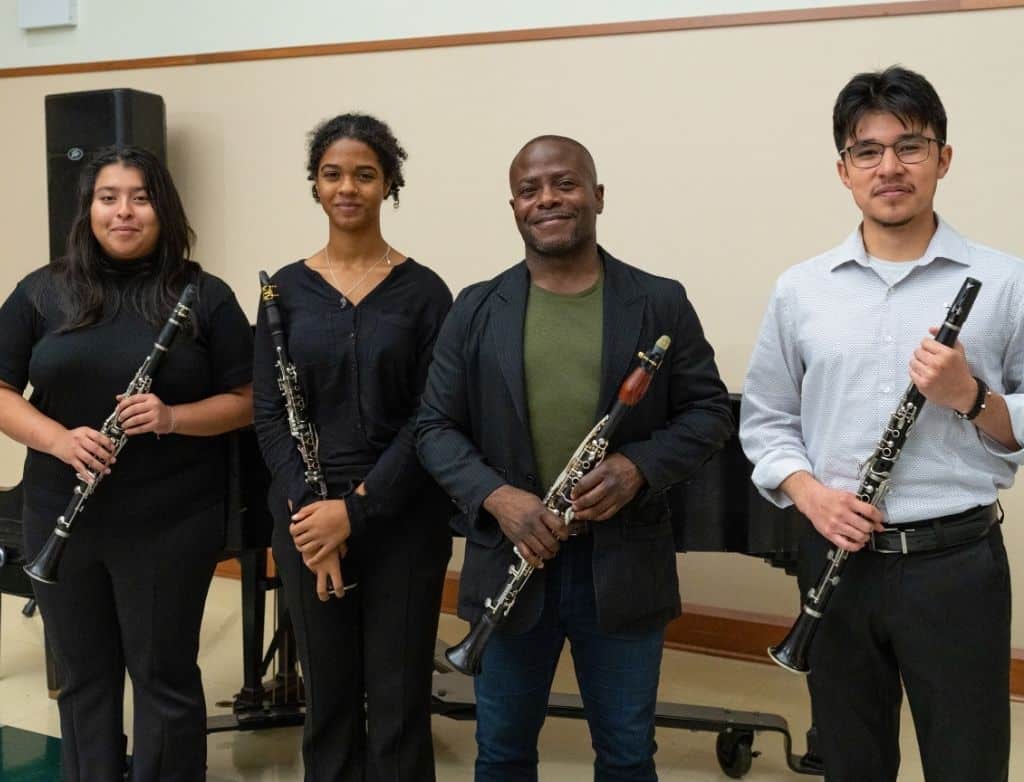 Three students stand with Anthony McGill. All are holding clarinets
