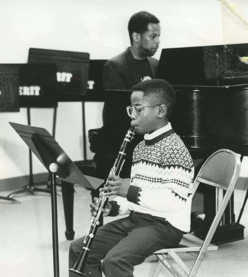 A black and white photo of a young Anthony McGill playing clarinet