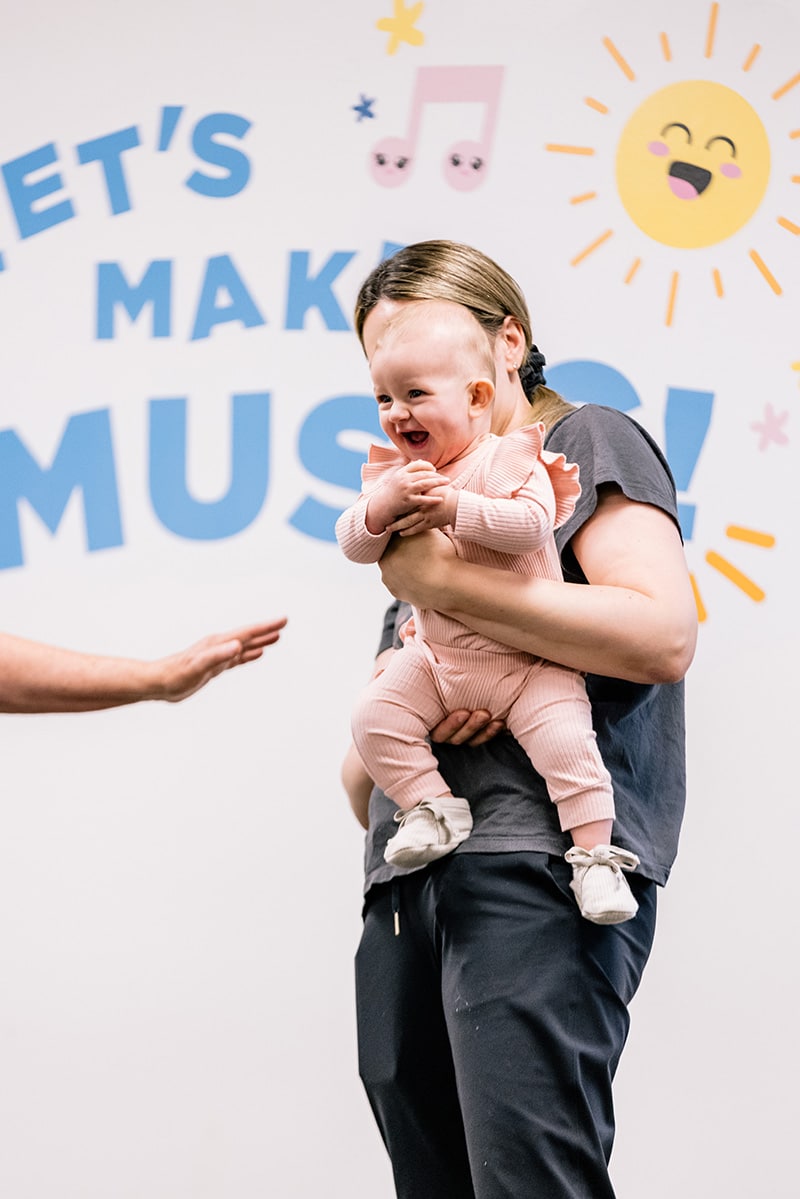 An excited baby laughing during an early childhood class
