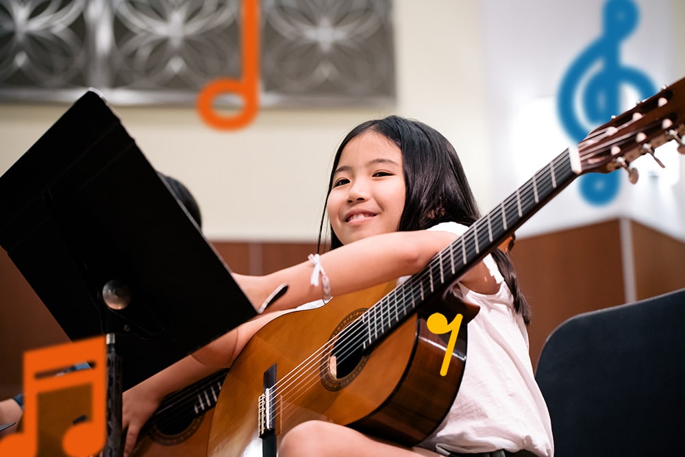 A young guitar student takes a short break during a group class