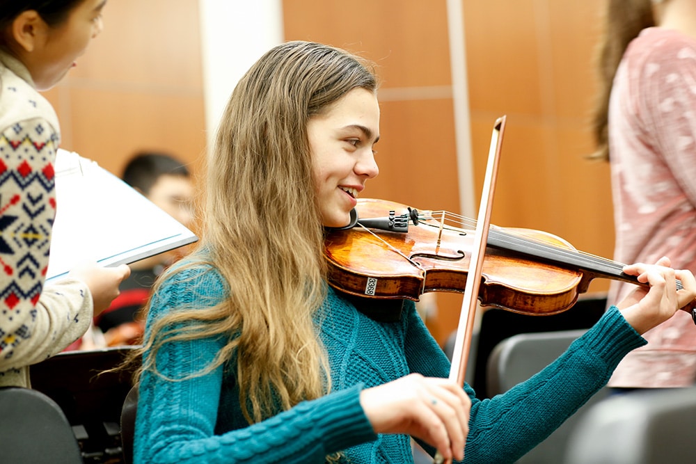 A strings player warming up before a rehearsal