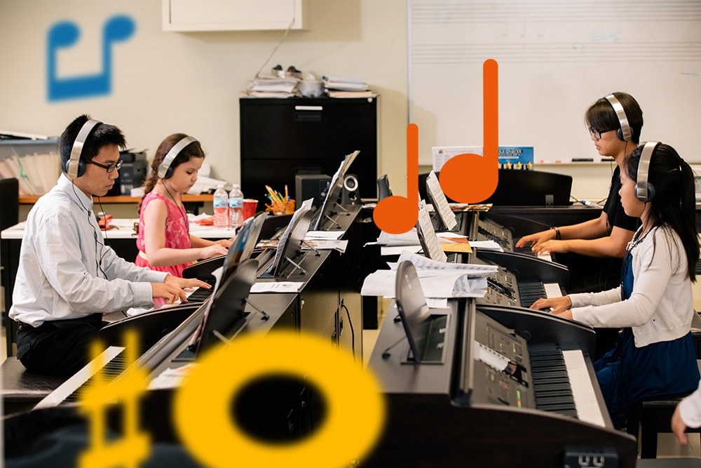 A group class wearing headphones as they practice piano