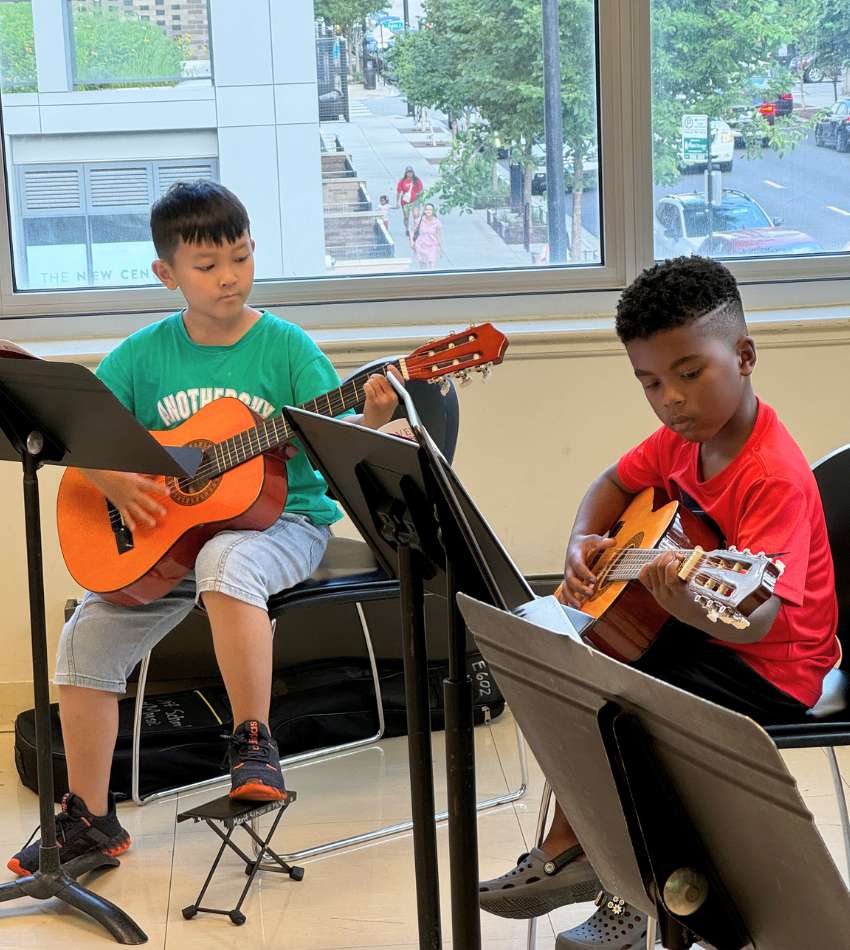 Two young students playing guitar