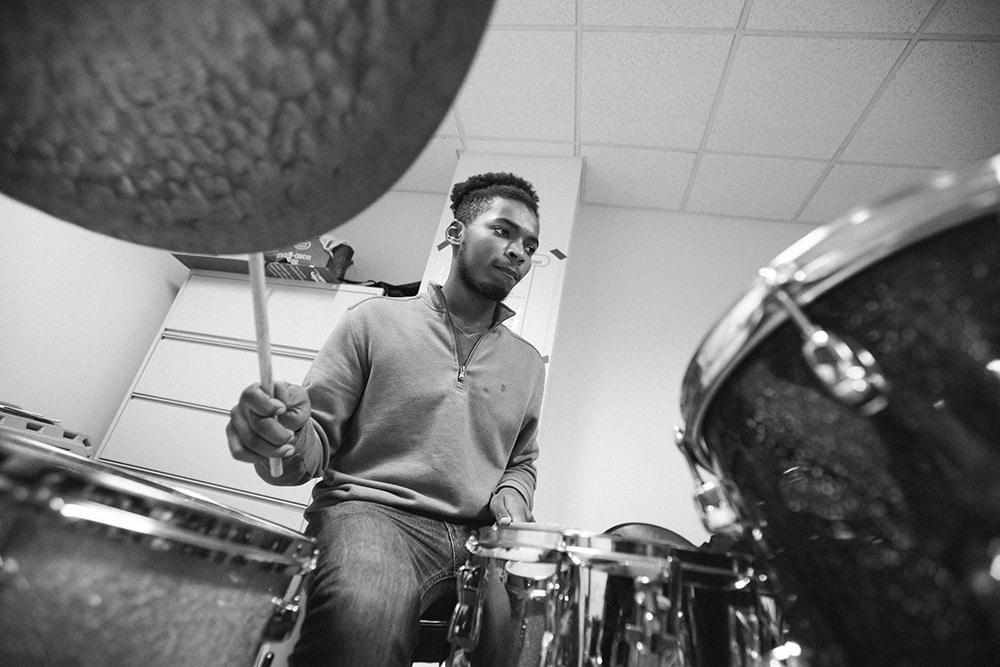 A merit student playing the drum kit