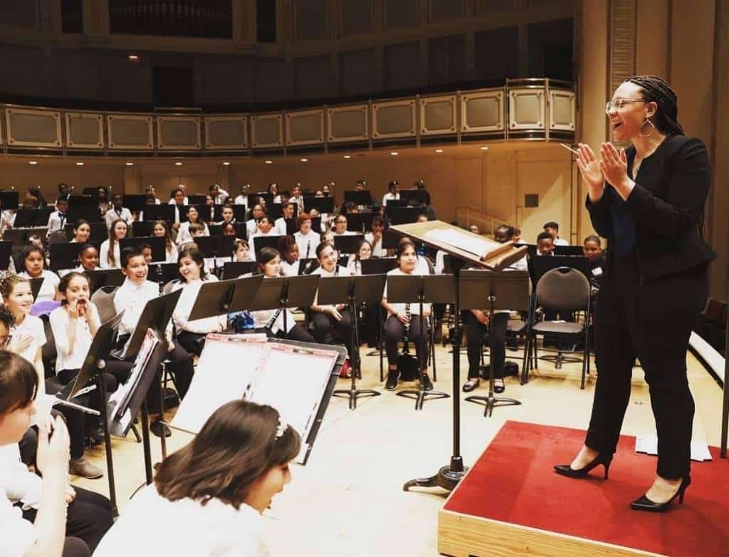 Kamila instructing a middle school orchestra.