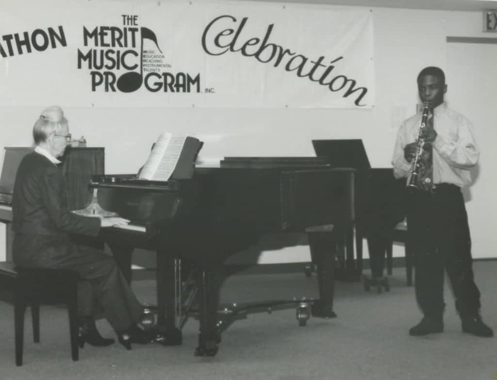 An old black and white photo of a teenage Anthony McGill playing clarinet with a pianist.