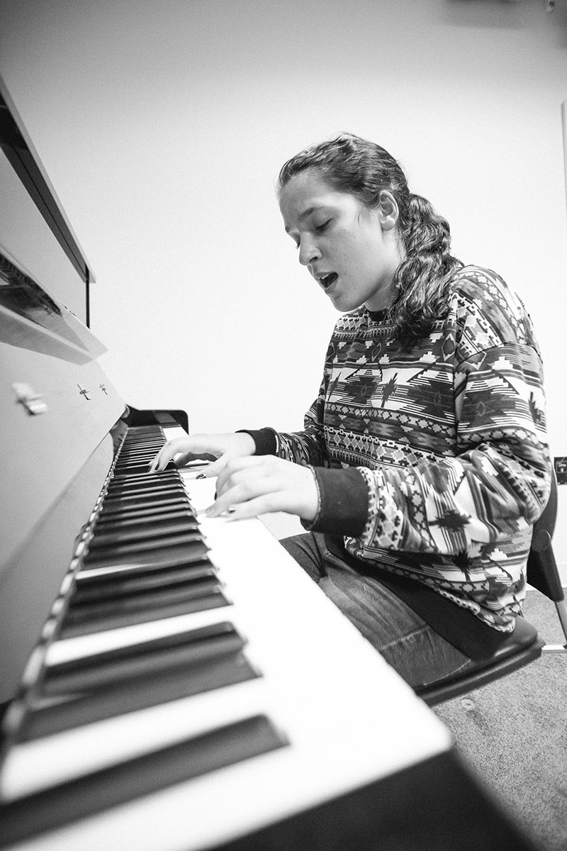 A piano student playing and singing