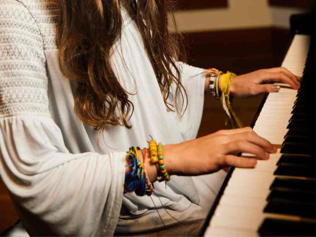 A close up photo of a student's hands while playing the piano