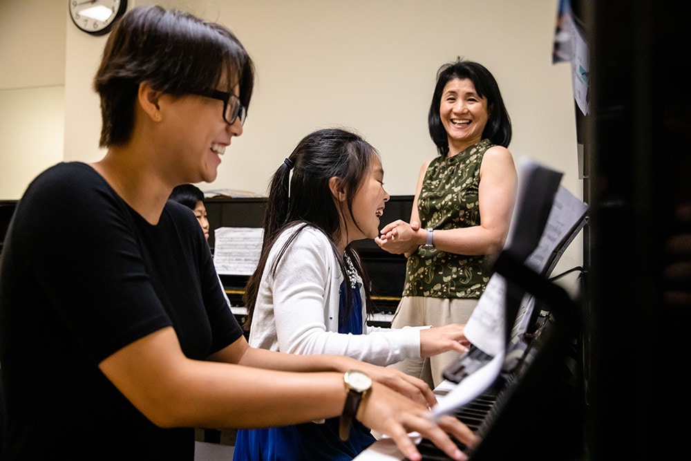Piano students and their instructor enjoying a fun moment