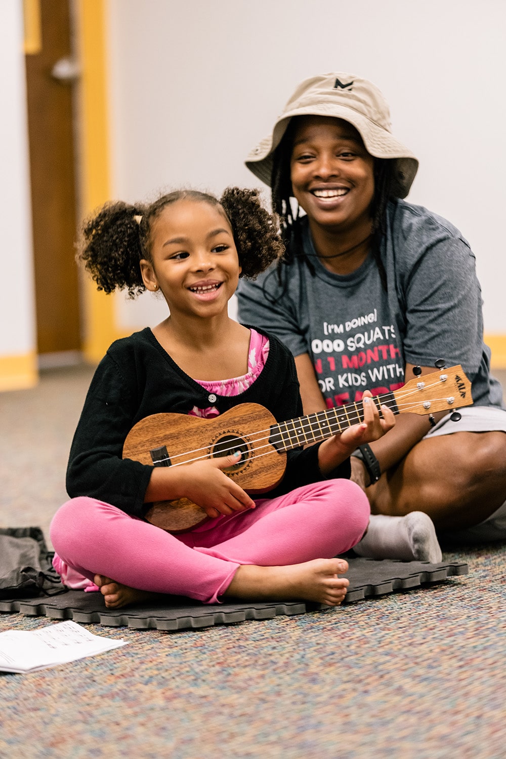A yound ukulele student and her mother during a group class