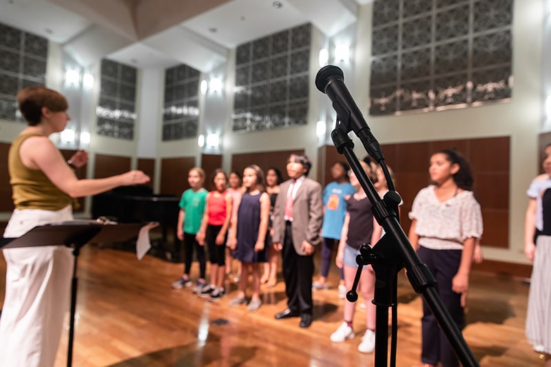 A vocal ensemble and their instructor during a performance