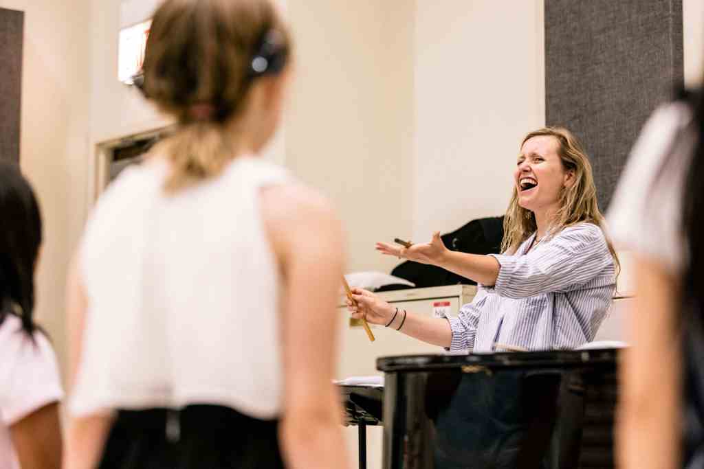 Voice instructor conducting her class with enthusiasm