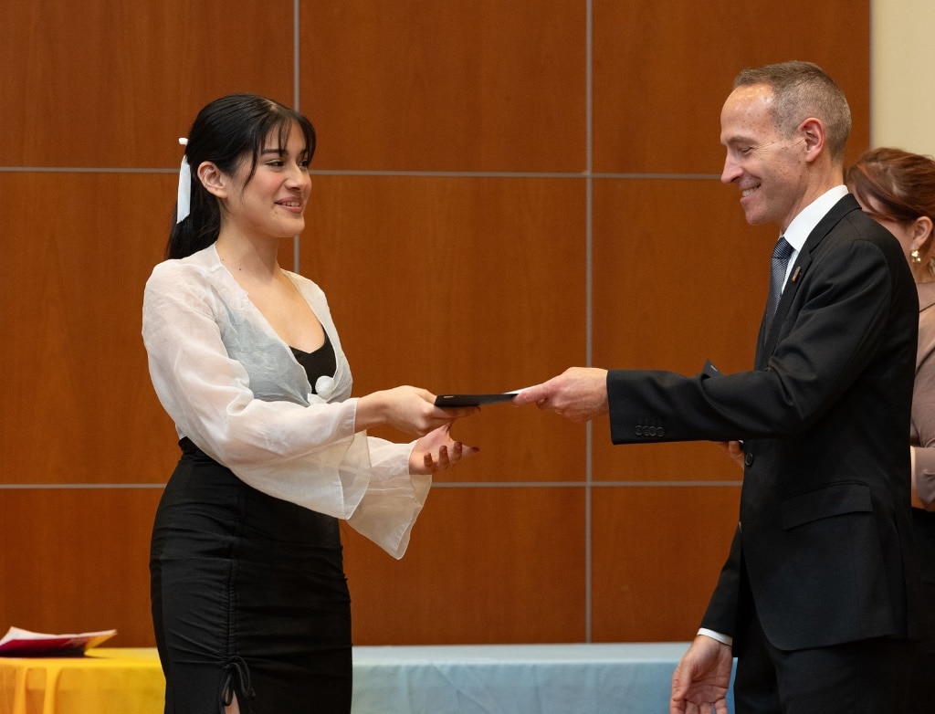 Yaretzi Lizama being handed her diploma by Charlie Grode