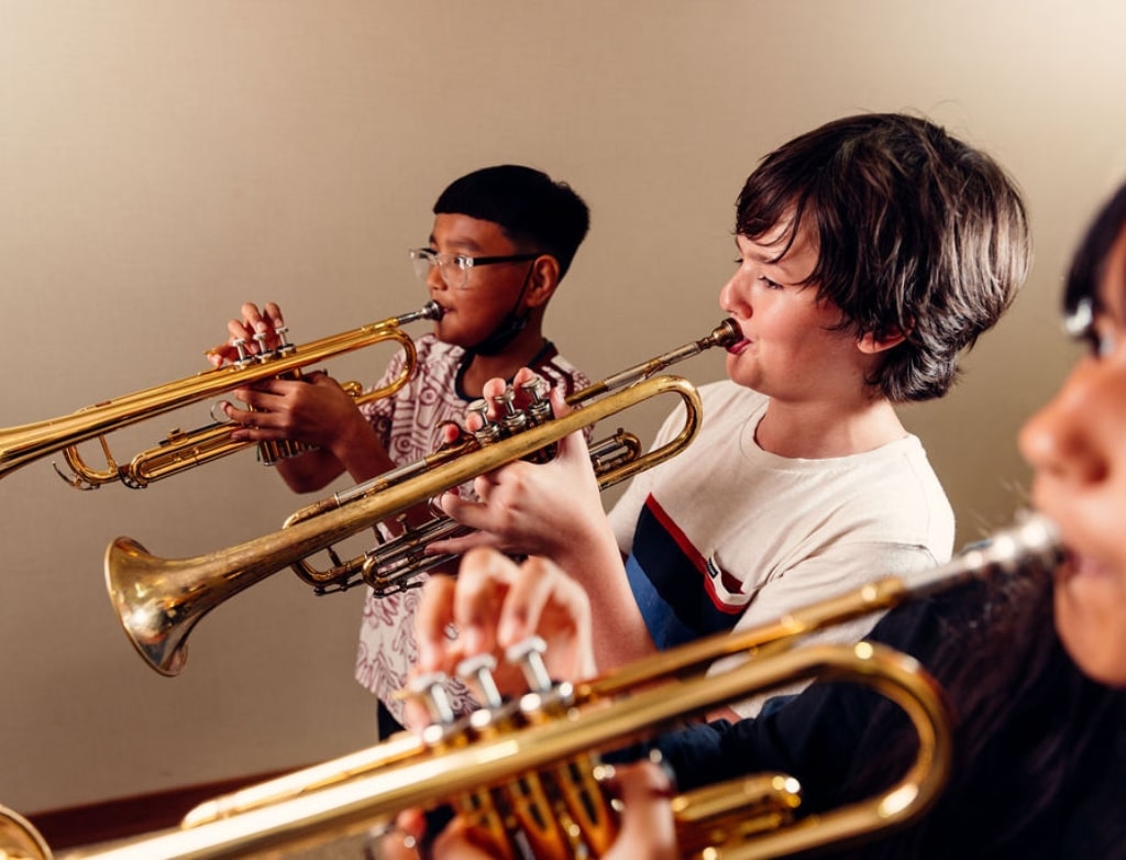 Young kids play music during trumpet camp at Merit School of Music