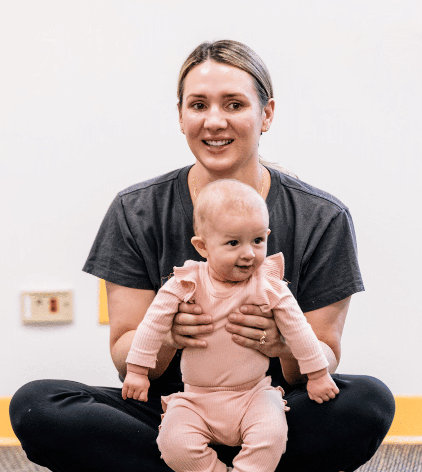 A parent holds her baby in an Early Childhood class.