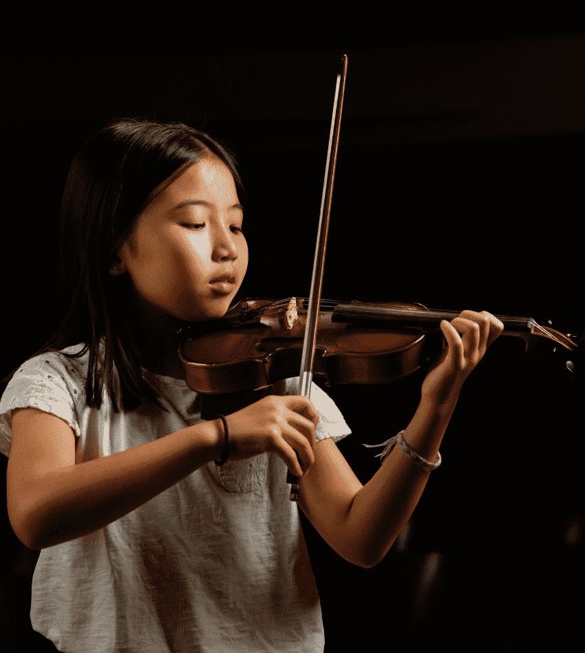 A violin student focuses on playing her instrument