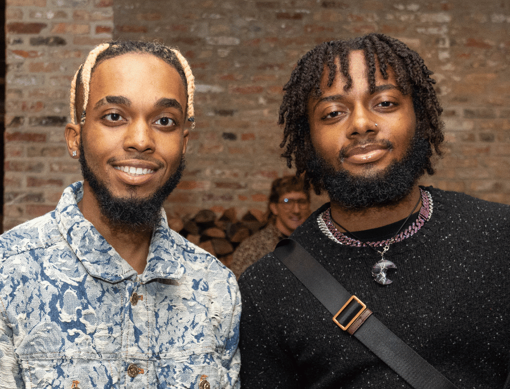 Bryce and Bruce Thompson stand next to each other, smiling.