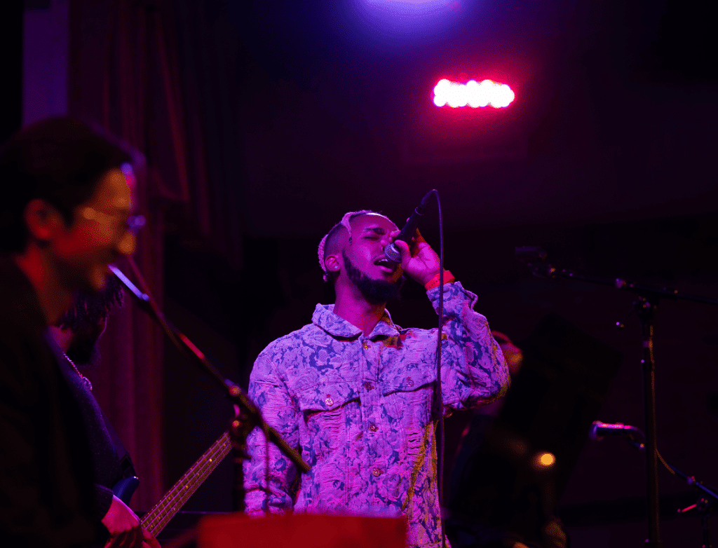 King Melik performs onstage at Play On with his band members.
