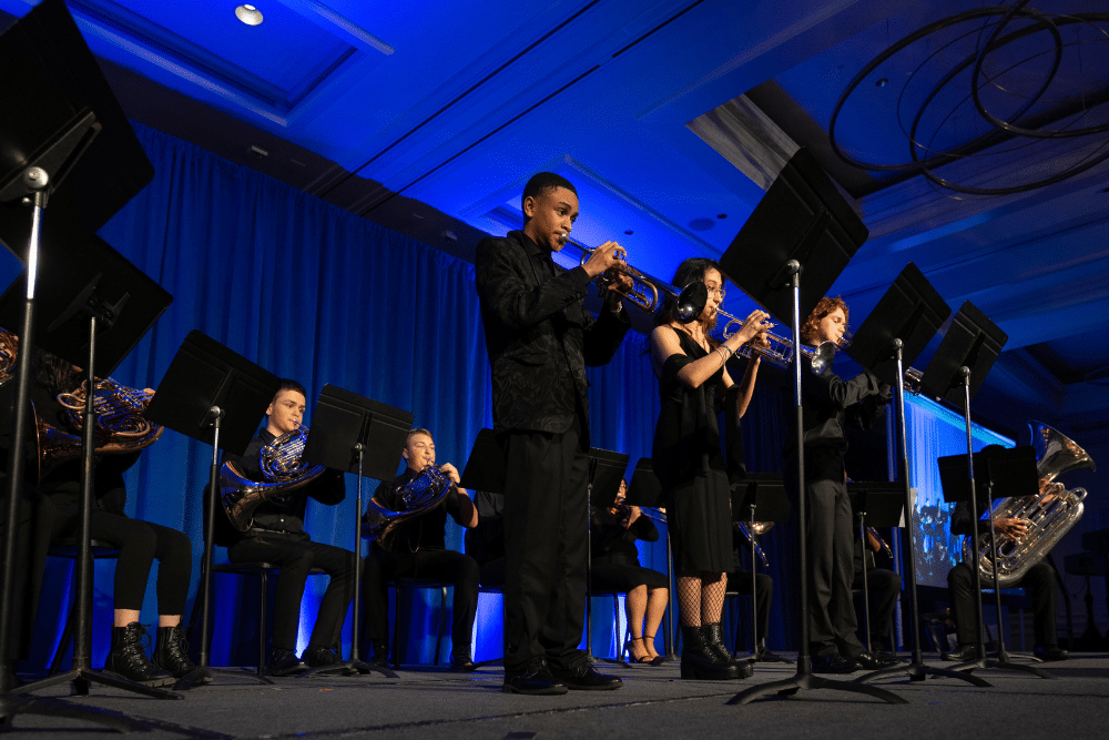 Students from the Merit Brass Ensemble performing on stage at Merit Gala 2023.
